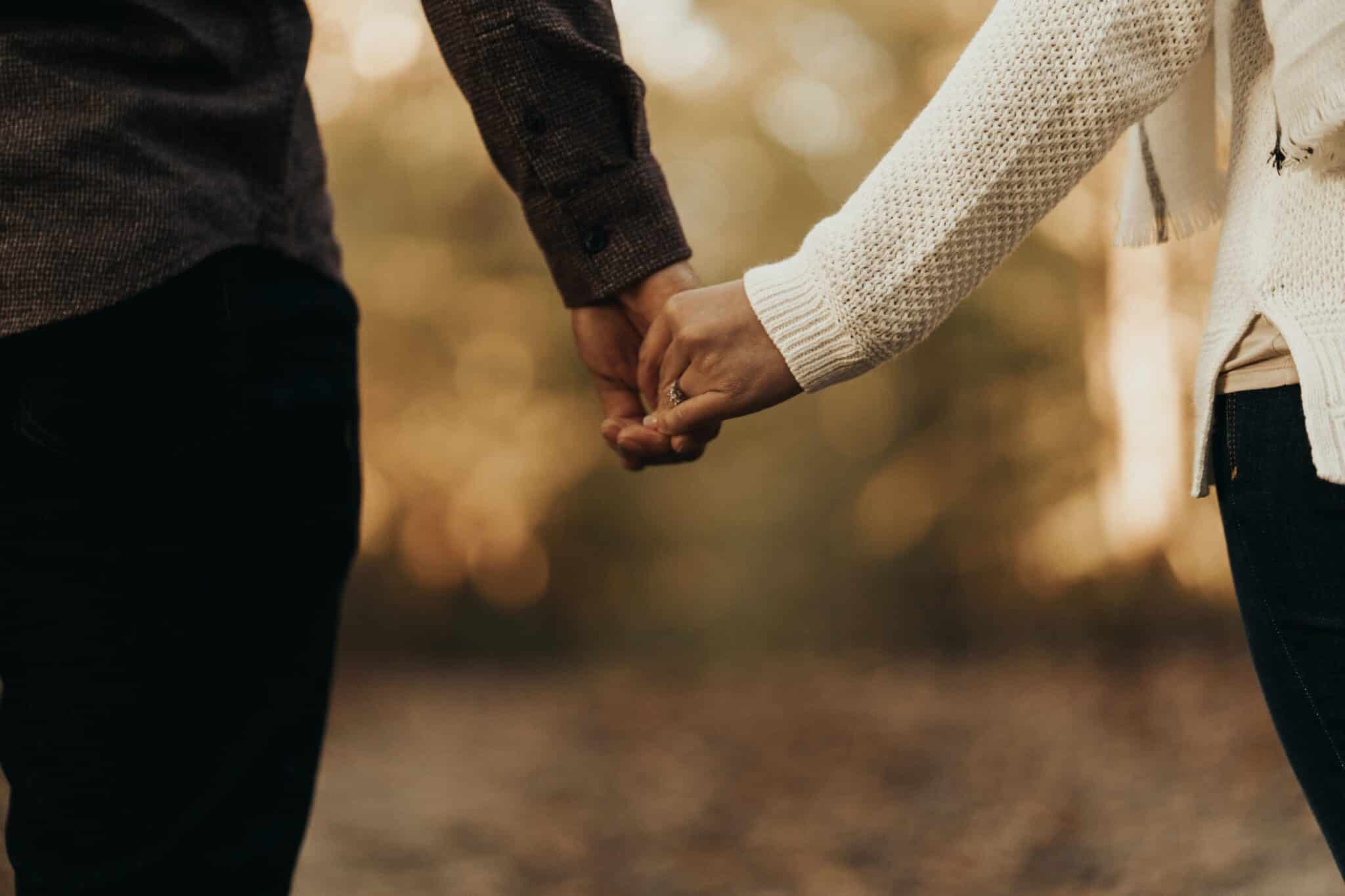 a married middle aged couple holding hands on a walk in the forest