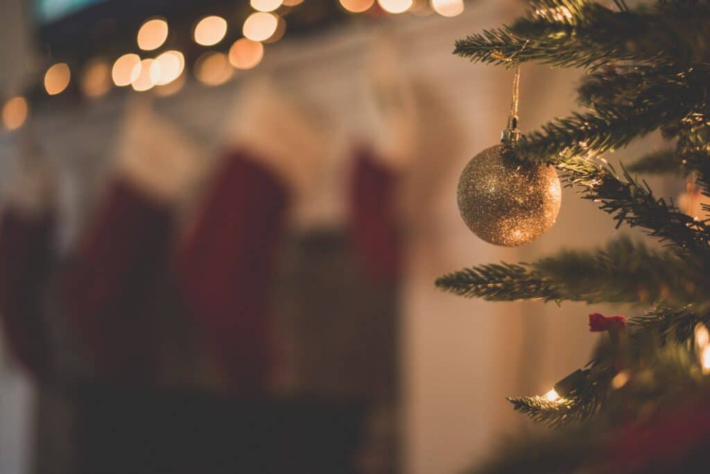 shimmering gold christmas bauble hanging from christmas tree