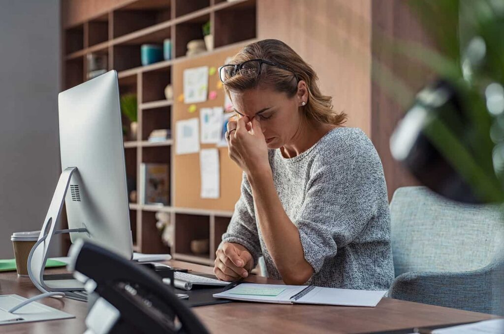 an upset woman in front of her computer at the beinging of divorce proceedings