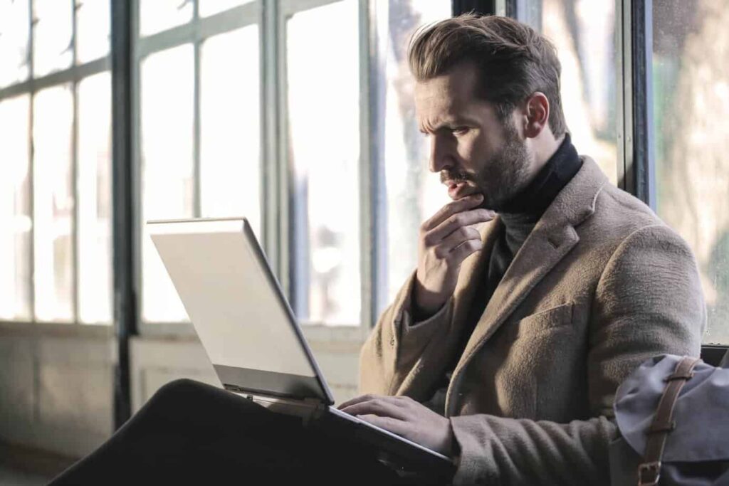 smartly dress thoughtful man using his laptop