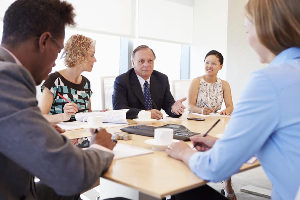 Five Businesspeople Having Meeting In Boardroom