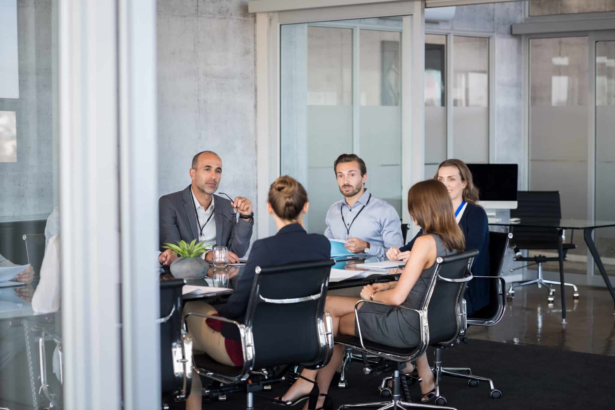 Business people sitting in boardroom and working together at new strategy plan. Group of leader and businesspeople in a meeting at office. Senior executive with his team working in a conference room.