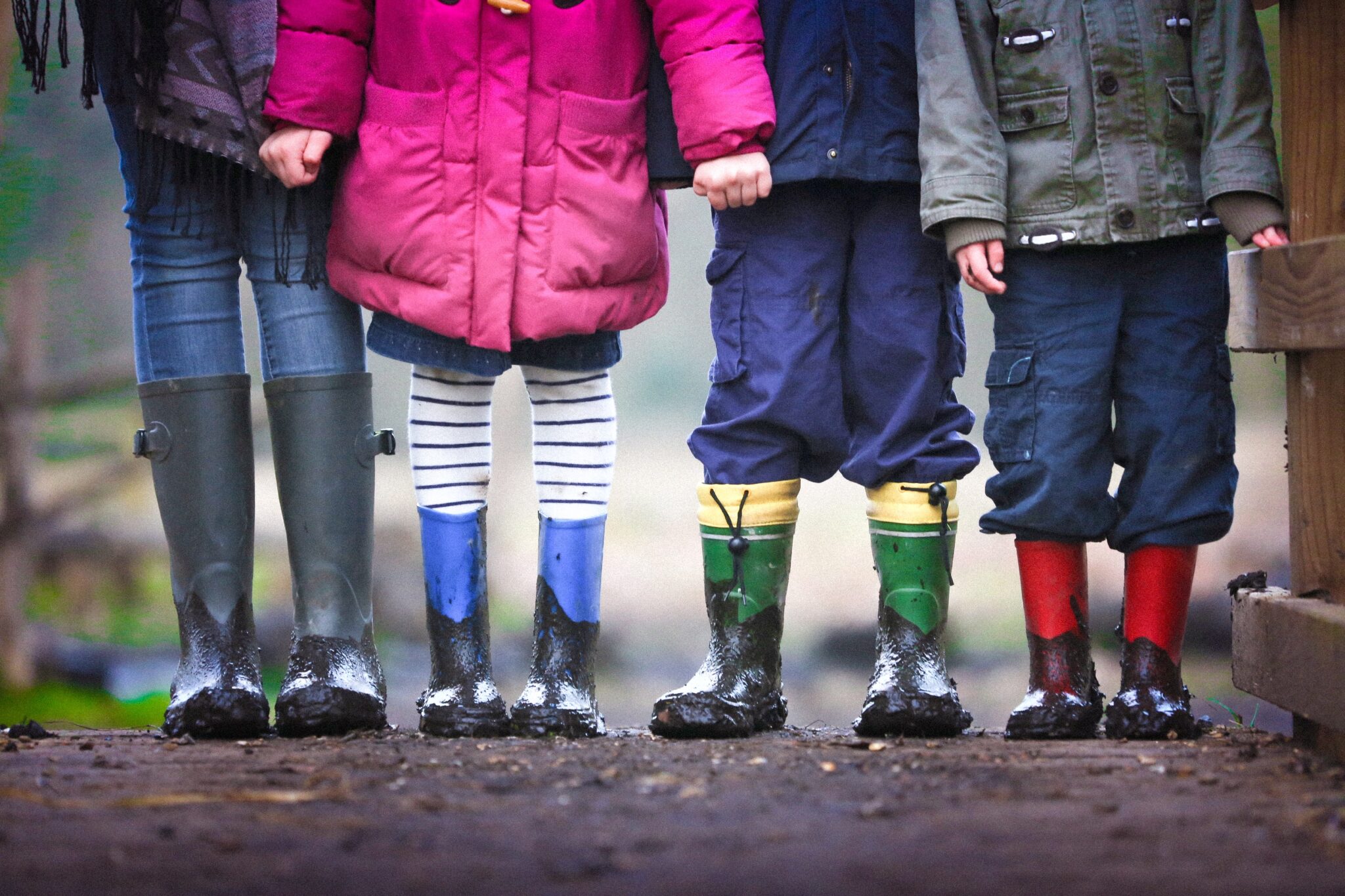 four children with muddly wellington boots