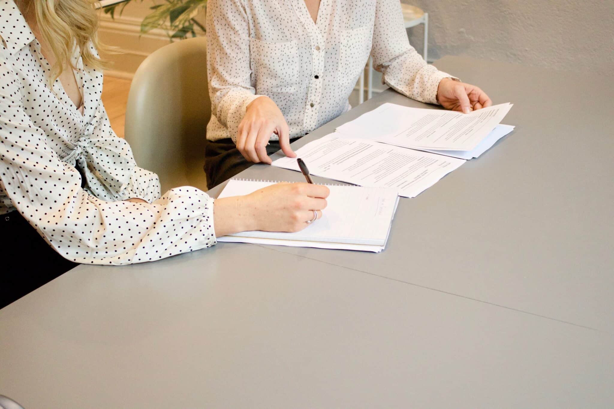 two ladies signing legal documents