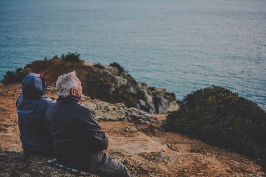 older couple on cliff looking out over the ocean