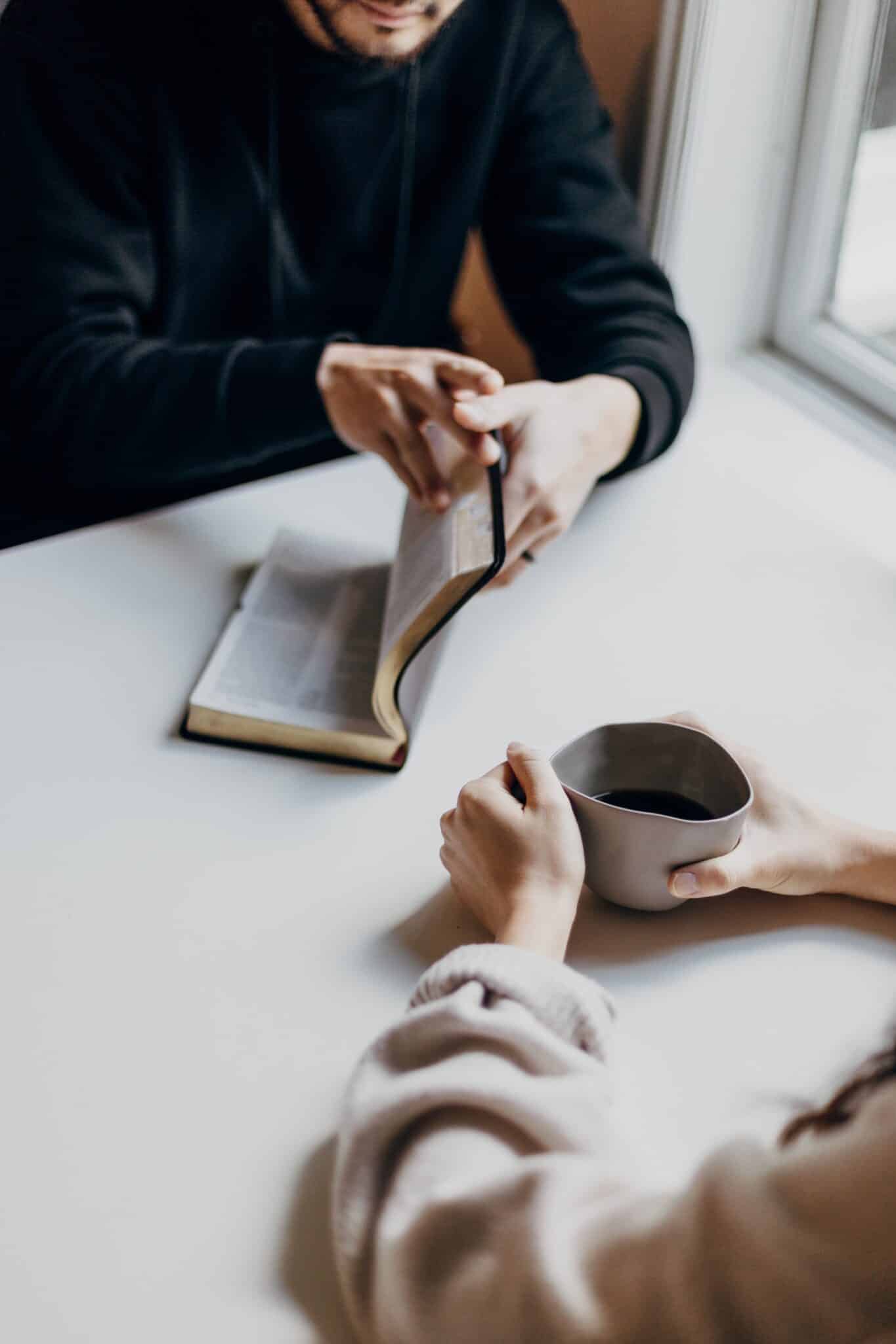 young couple in front of window reading and drinking coffee